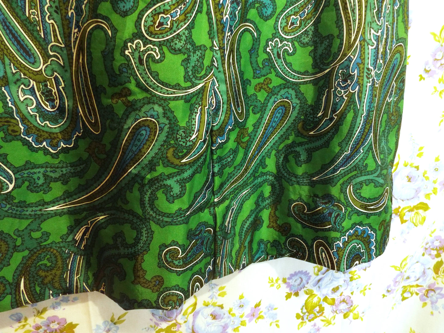 Vintage Handmade Paisley Dress (S-M) in a green and black paisley print, against patterned fabric with blue and purple roses.