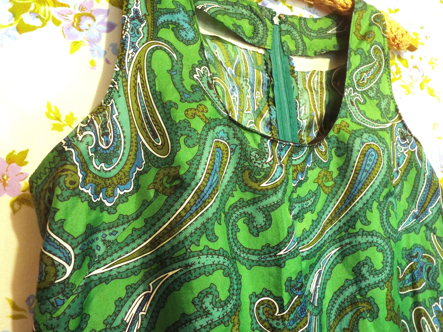 Vintage Handmade Paisley Dress (S-M) in a green and black paisley print, against patterned fabric with blue and purple roses.