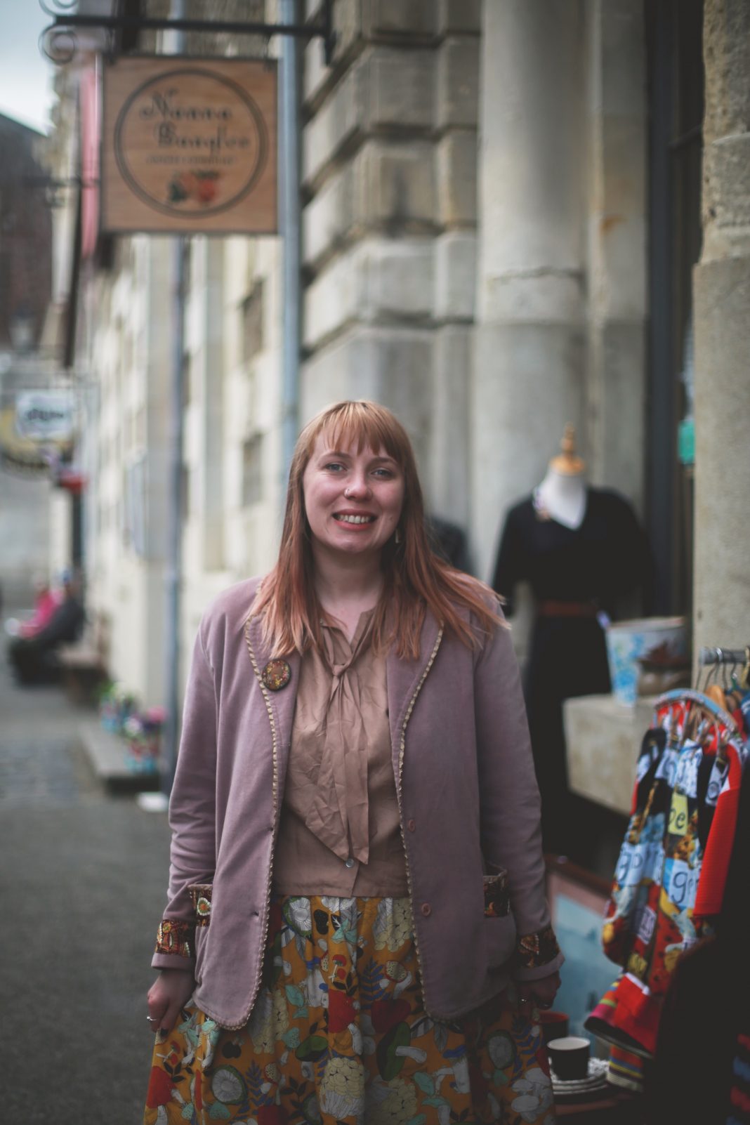 Photograph from the Oamaru Mail newspaper of Livvi smiling outside the Nanna Bangle shop in the Victorian Precinct, Oamaru, New Zealand.