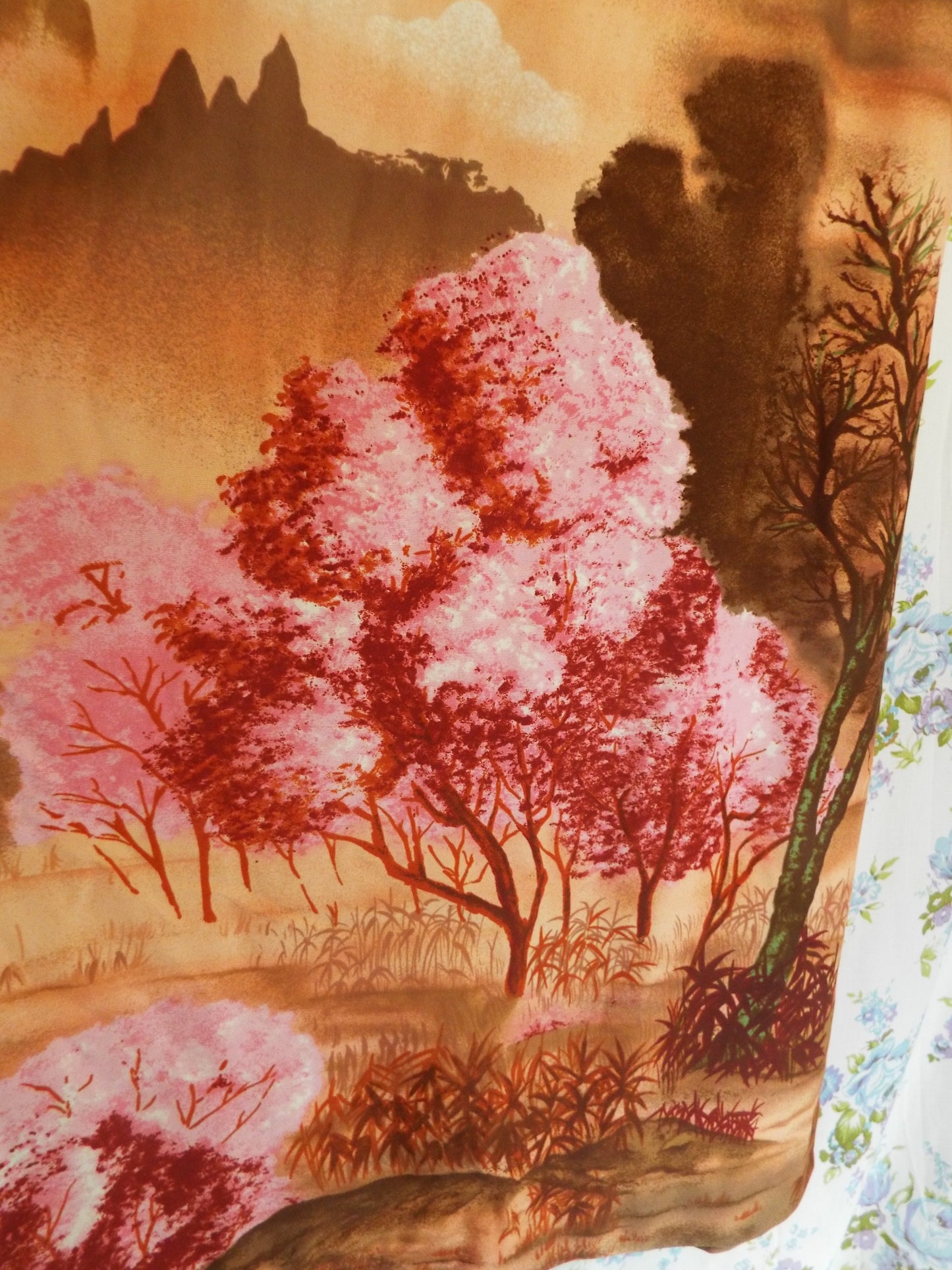 Close-up of pink trees printed on 1970s Maxi Dress with Ducks (S-M), against patterned fabric with blue and purple roses.