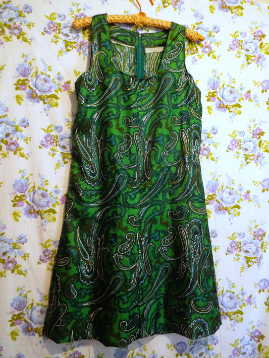 Vintage Handmade Paisley Dress (S-M) in a green and black paisley print, against patterned fabric with blue and purple roses.
